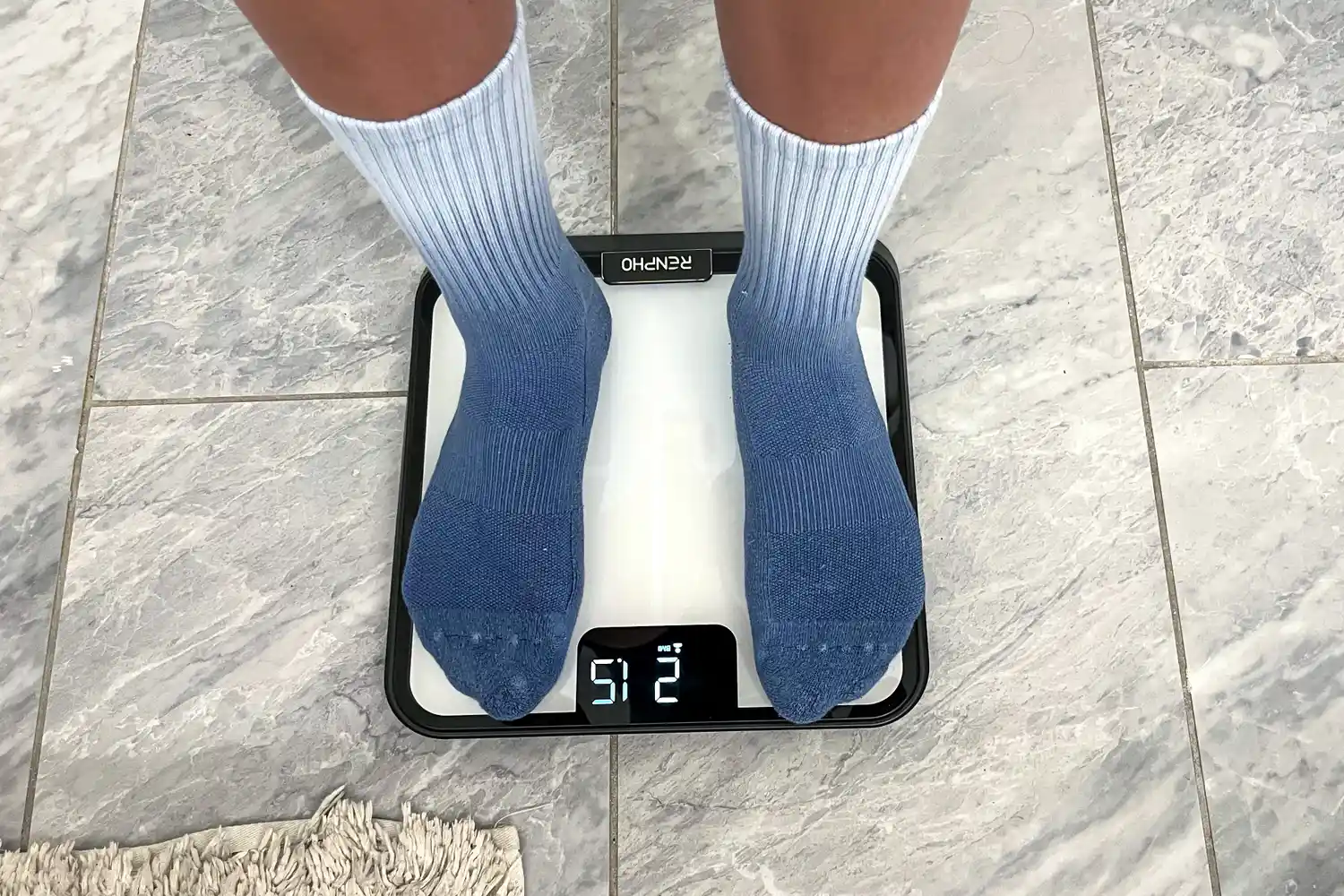 A person stands on the Renpho R-MSB02 Elis Chroma Aspire Smart Scale in socks