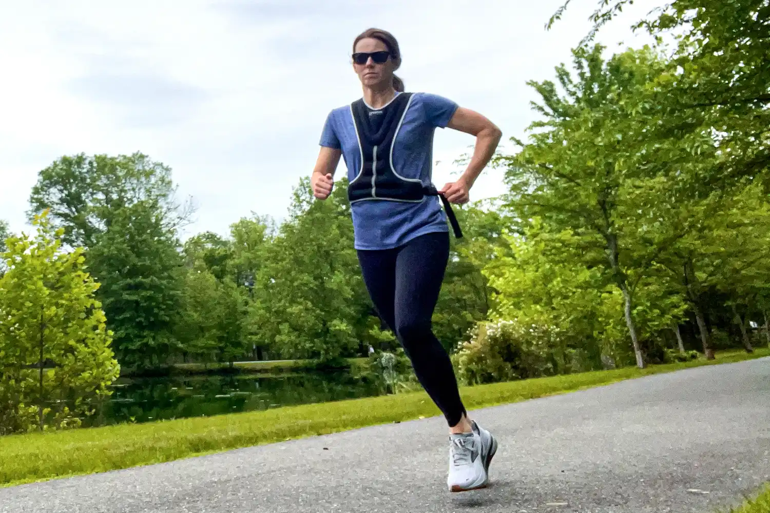 A person runs outside while wearing the Tone Fitness HHWV-TN Weighted Vest